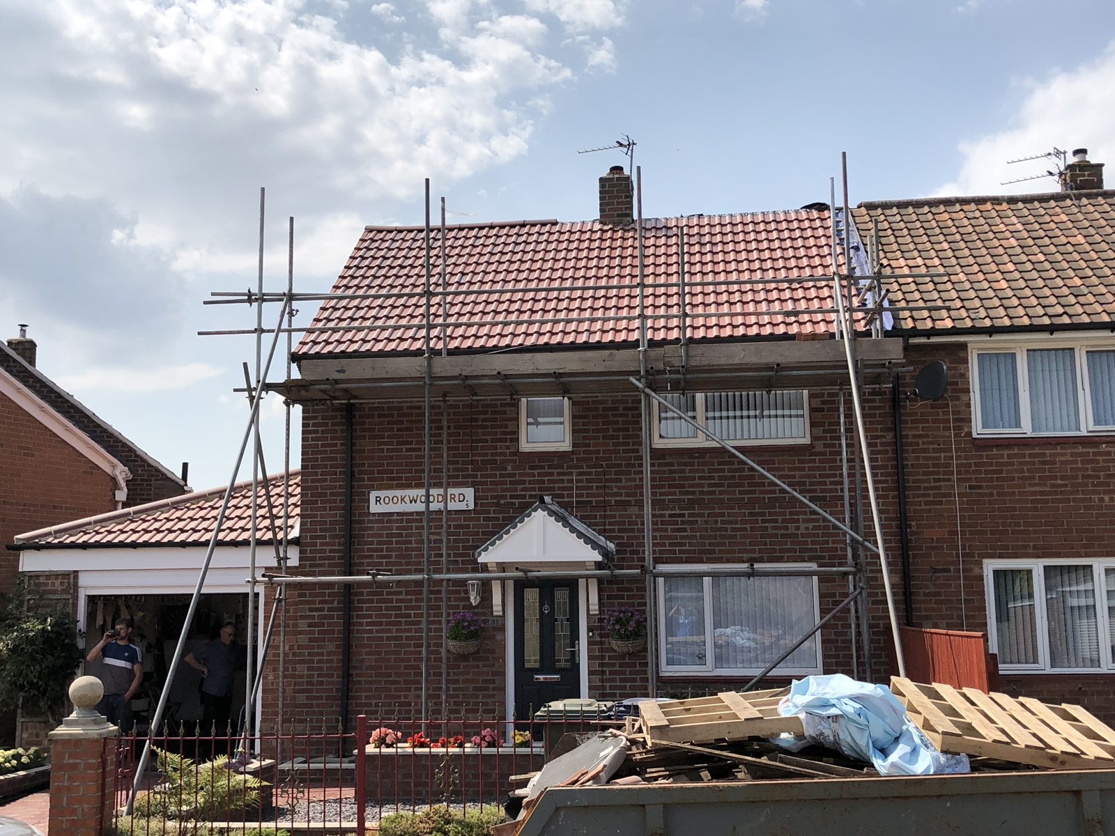 A brick semi with scaffolding up for work on the roof